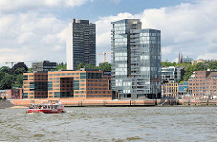 Blick über die Elbe - Wohnhäuser, Hochhäuser am Elbufer von Hamburg Altona / Grosse Elbstrasse. Barkasse mit Fahrgästen bei einer Hafenrundfahrt.