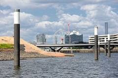 Neu eingelassene Stahldalben im Hamburger Baakenhafen - lks. Teile der neu aufgeschütteten Insel, die als Spielinsel / Freizeitinsel  in der Hafencity geplant ist.