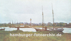 Blick über das Köhlfleet nach Finkenwerder; am Ufer liegt ein Segelschiff vor Anker, ein anderes hat den den Dalben fest gemacht. Im Hintergrund die Finkenwaerder Landungsbrücken an der eine Hafenfähre angelegt hat - zwischen den Häusern Finkenw