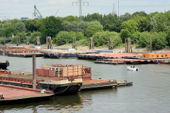 Pontons im Travehafen in Hamburg Steinwerder - ein Sportboot fährt zwischen den Arbeitsschiffen.