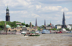 Panorama der Hansestadt Hamburg - Blick über die Elbe zur den Türmen der Stadt: ganz links der Kirchturm der St. Michaeliskirche, dann die Spitze vom Rathausturm; daneben der Pegelturm der St. Pauli Landungsbrücken und der Kirchturm der Petrikirche.