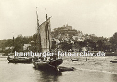 historisches Foto von Hamburg Blankenese; zwei Fischerboote liegen am Elbstrand - im Hintergrund die Häuser des Fischerdorfes Blankenese und der Süllberg.