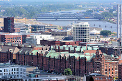 Kupferdächer der historischen Hamburger Speicherstadt und moderne Neubauten in der neuen Hafencity - im Hintergrund die Norderelbbrücken.