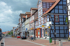 Geschäftsstrasse / Durchgangsstrasse mit historischer Bebauung - farbige Fassade, Fachwerkkonstruktion - Gewitterhimmel; Lange Strasse in Lüchow.