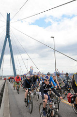 Fahrradsternfahrt in Hamburg - FahradfahrerInnen auf der Köhlbrandbrücke - im Hintergrund Containerbrücken vom Waltershofer Hafen.