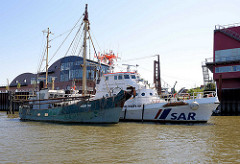 Fischkutter HBK 92 und das SAR Schiff Fritz Behrens am Anleger in Hamburg Finkenwerder; der Seenotrettungskreuzer wurde 1981 gebaut und hat zwei Dieselmotoren mit 2076 PS.