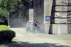 Der Sockel vom Hamburger Bismarckdenkmal ist mit Grafitti beschmiert; Arbeiter säubern den Stein mit Druckluft.