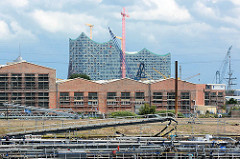 Bilder aus dem Hamburger Hafen - Lagerhallen in Hamburg Steinwerder - dahinter das Gebäude der Elbphilharmonie in der Hafencity.