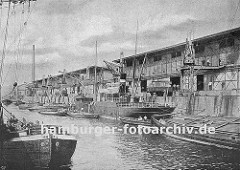 Hafenkai in Hamburg Altona - ein kleiner Frachter liegt an der Kaimauer, seine Ladung wird auf Schuten gelöscht; der Lastkahn re. hat seinen Laderaum mit Holz abgedeckt, damit seine Fracht nicht nass werden kann. (ca. 1935)