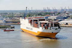 Der RoRo Frachter GRANDE COTONOU läuft in den Hamburger Hafen ein - ein Schlepper zieht das Frachtschiff zu seinem Liegeplatz im Hansahafen.