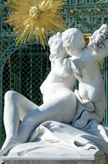 Skulptur Flora mit Zephir am Gitterpavillon beim Schloss Sanssouci - goldenes Sonnensymbol.