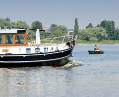 Angler im Ruderboot auf dem Grossen Zemsee - eine Barkasse fährt auf der Havel.
