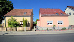 Zwei Wohnhäuser in gleicher Bauform, unterschiedliche Fassadengestaltung und Vorgärten mit Zaun - Architekturfotos aus Werder / Havel