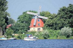 Windmühle am Ufer der Havel in Werder - auf den Flügeln Photovoltaikmodule / Sonnenkollektoren angebracht, die den Solarstrom für die Bewohner generieren. Das Obergeschoss  ins um 360 Grad drehbar, so dass die Solarstromanlage der Sonne nachgeführt w