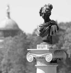 Bronzebüste auf einer Säule am Schloss Charlottenhof Park Sanssuci / Potsdam - im Hintergrund die Kuppel vom Neuen Palais.