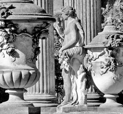 Deckelvasen mit Dekor - Skulptur zwischen kannelierten Säulen im Park Sanssouci von Potsdam.