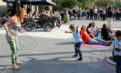 Grillfest von AnwohnerInnen und Flüchtlingen im Hamburger Karoviertel; Kinder spielen mit Hula Hoop Reifen.