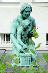 Bronzeskulptur Frau mit Kind - Spardose an der Max-Brauer-Allee - Gebäude Altonaer Spar- und Bauverein; Bildhauer O. G. Hermann Perl.