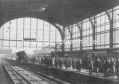 Altes Foto, Bahnsteig Bahnhof Altona - ein Zug mit Lokomotive fährt ein, auf dem Bahnsteig warten Reisende, ca. 1935.