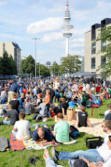 Grillfest von AnwohnerInnen und Flüchtlingen im Hamburger Karoviertel. Wiese am Tschaikowsky-Platz - im Hintergrund der Hamburger Fernsehturm.