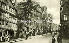 Historische Bilder aus dem Hamburger Gängeviertel - Geschäfte, Lederhandlung in der Strasse Teilfeld - Blick vom Herrengraben; Frauen mit Schürze auf der Strasse, Hund und Passanten auf dem Bürgersteig.