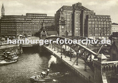Blick über den Zollkanal ca. 1930 zum Messberg; Schlepper mit Kahn unter der Wandrahmbrücke, ein Lastwagen mit Anhänger fährt über die Brücke in den Hamburger Freihafen. Rechts der Messberghof und lks. das Chilehaus.; dahinter die Turmspitze der