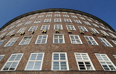 Architekturbild von der runden Ecke des Hamburger Kontorhauses Sprinkenhof Buchardstrasse / Johanniswall; in Goldbuchstaben steht der Name SPRINKENHOF an der Fassade des Bürogebäudes.