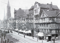 Geschäfte in der Steinstrasse in der Altstadt Hamburgs - weisse Markisen schützen die Auslage im Fenster vor der Sonne - Schilder Fleischwaaren-Handlung / Schuhreparatur, Werkstatt mit elektrischem Betrieb; Fussgänger und Pferdewagen - im Hinterg