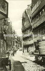 Historische Bilder aus dem Hamburger Gängeviertel - Fuhrwagen mit Fässern, Handkarre am Strassenrand - Fussgänger in der Strasse Herrlichkeit.