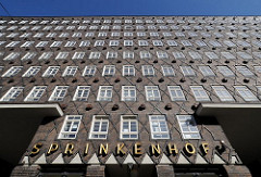 Fassade des Hamburger Kontorhauses Sprinkenhof, der Schriftzug steht in goldenen Lettern über dem Eingang.