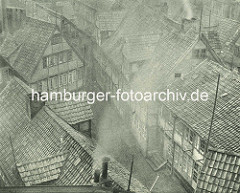 Alte Fotos aus dem Gängeviertel Hamburgs - Blick   auf Hausdächer im Schulgang, rauchender / qualmender Schornstein auf einem Hausdach.