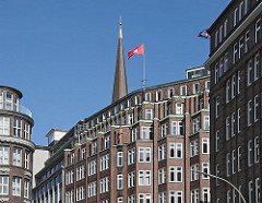 Hausfassaden im Hamburger Kontorhausviertel an der Strassenkreuzung Schopenstehl, Niedernstrasse und Kattrepel; auf dem Dach des Bürogebäudes Montanhof weht die Hamburg Fahne - dahinter die Spitze vom Kirchturm der Hamburger Hauptkirche St. Jakob