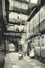 Historische Bilder aus dem Hamburger Gängeviertel -  Blick vom Breiten Gang durch die Toreinfahrt zum Kornträgergang; Kinder, Mädchen mit Schürzen.