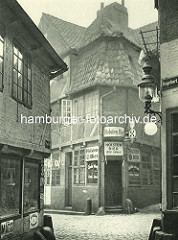 Alte Fotos aus dem Gängeviertel Hamburgs - Kneipe mit Schildern Holsten Bier Ecke Schulgang / Ebraeer Gang.