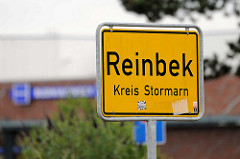 Gelbes Ortschild, schwarze Schrift - Reinbek, Kreis Stormarn.