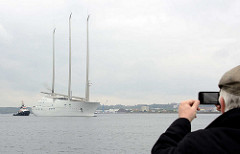 Die Segelyacht White Pearl kehrt von einer  Probefahrt in den Kieler Hafen zurück; ein Tourist fotografiert mit seinem Handy / smartphone die Szene.
