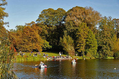 Kanus auf dem Stadtparksee in der Herbstsonne - die Blätter der Bäume sind herstlich gefärbt; Bilder aus Hamburg Winterhude.