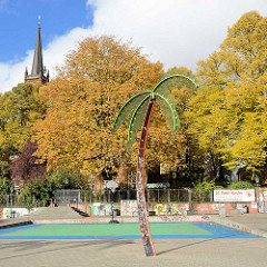 Park Fiction / Antonipark / Gezi Park in Hamburg St. Pauli - Eisenpalme, herbstliche Bäume, Kirchturm der St. Pauli Kirche.