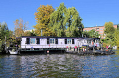 Hausboot und Herbstbaum an der Bille in Hamburg Hamm.