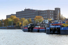 Blick über den Peutehafen auf der Veddel - re. Schubschiffe am Ufer, im Hintergrund die Industriearchitektur / Klinkergebäude der ehem. GEG an der Peutestrasse.