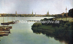 Alte Segelboote / Holzboote liegen am Steg an der Rabenstrasse, Aussenalster - im Hintergrund die Lombardsbrücke und Kirchtürme der Hansestadt Hamburg.