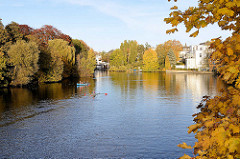 Herbst in der Hansestadt Hamburg, Herbstbäume am Ufer vom Langen Zug an der Hamburger Aussenalster - im Hintergrund der Mühlenkamper Anleger in Hamburg Winterhude.