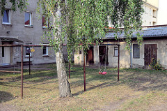 Hinterhof mit Kinderspielplatz, Teppichstangen und Schuppen in Oranienburg.