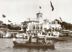 Regatta auf der Hamburger Aussenalster - beim Uhlenhorster Fährhaus ist das Schild Ziel angebracht - dicht besetzte Ruderboote mit Frauen und Männern.