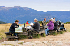 Ruheplatz / Rastplatz für die WanderInnen an der Elbquelle im Riesengebirge - an Holzbänken und Holztischen sitzen die Touristen, machen Brotzeit oder studieren die Karten.