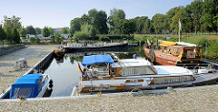 Marina an der Havel in Oranienburg - Motorboote liegen geschützt im Hafenbecken - im Hintergrund ein Wohnmobilstellplatz.