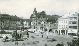 Historische Ansicht vom Karlsplatz / Karlovo náměstí in Kolin -  städtische Architektur des späten Barock, Renaissance und klassizistischer Historismus. Marktstände sind abgeräumt - der Marktplatz wird mit einem Reisigbesen gefegt; Fassadenschild