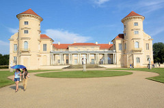 Hauptflügel vom Schloss Rheinsberg - Touristinnen mit  Sonnenschirm.