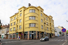 Architektur der 1920er Jahre - Eckwohnhaus / runde Ecke mit gelber Fassade in Kolin