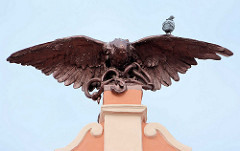 Falke / Raubvogel - Skulptur auf dem Dach vom SOKOL-Gebäude in Kolín; eine Taube sitzt auf der Schwinge des Vogels, der eine Schlange in den Fängen hält.